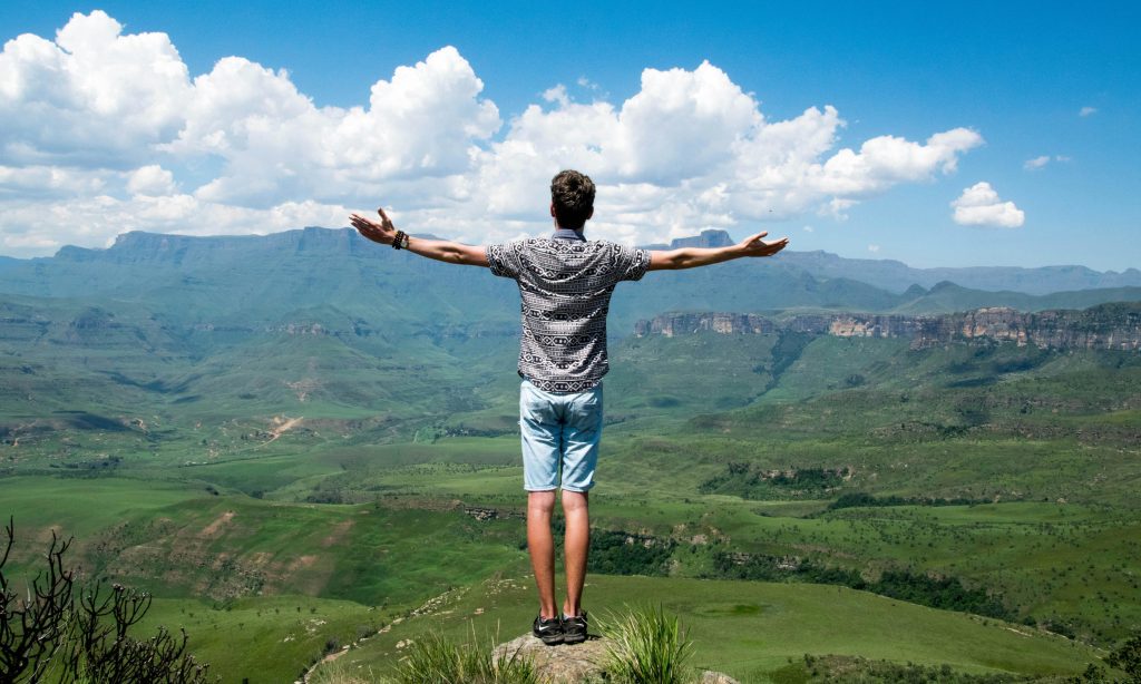man on top of a mountain admiring the view